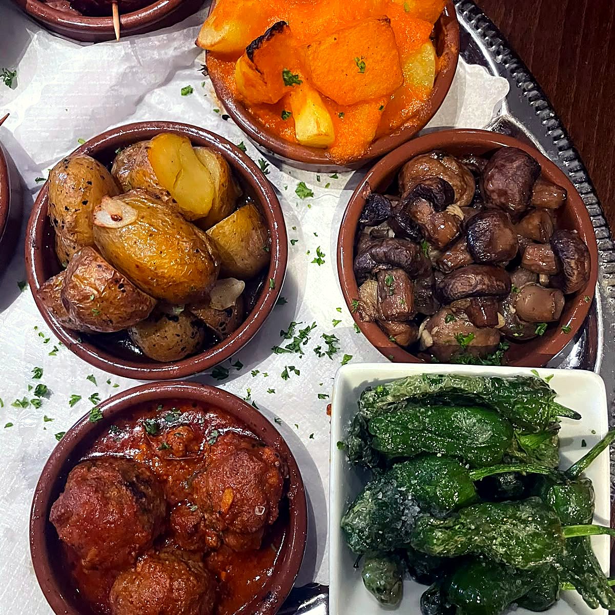 Tapas-Auswahl mit Albóndigas, Pimientos de Padrón, Pilzen und Kartoffeln